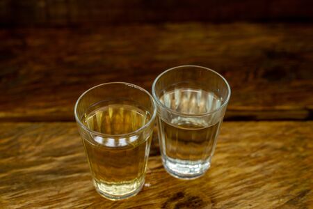 Several glasses of brazilian cachaÃ§a isolated on rustic wooden background, variations and types of brazil cachaÃ§a, typical drink from brazil.の写真素材