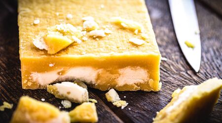 rapadura cut on rustic wooden table. Sugar cane candy, Brazilian dessert.の写真素材