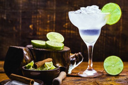 Frozen margarita in glasses, refreshing lemon alcohol drink and lots of ice, summer drink. Margarita ingredients, sugar, cinnamon, ice and chopped fruit.の写真素材