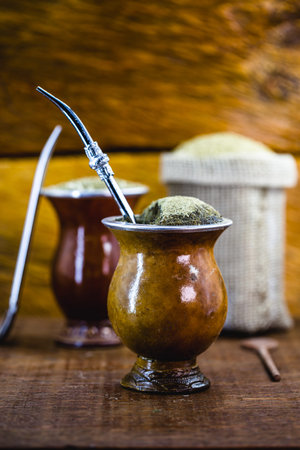 Yerba mate tea in calabash on wooden table. Traditional Argentine, Uruguayan and Brazilian drink....