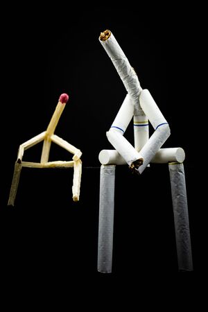 Image of a character made of cigarette, with matchsticks next to it, on black background. Concept of bad company. We are friends, a toxic friendship.の写真素材