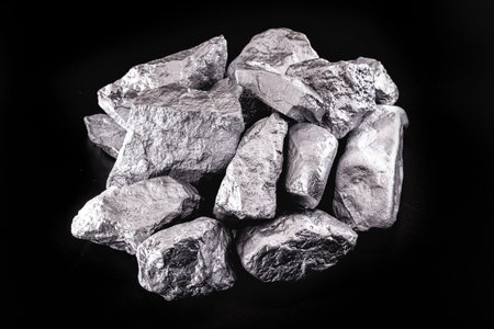 piece of silver or platinum on the stone floor, on black background. Export ore from south africa