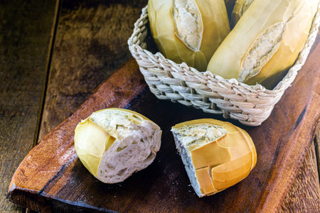 several traditional breads from brazil, on a rustic wooden background in a straw basket. National...