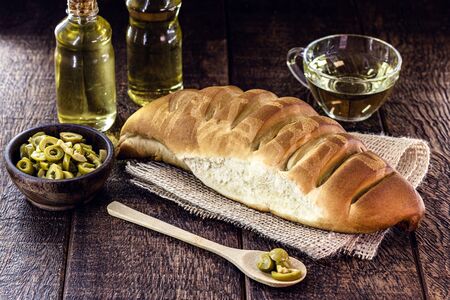 Homemade bread, made from olive oil, on a rustic wooden table. Organic bread, vegetarian diet.の写真素材