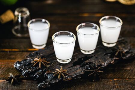 Traditional arabic alcohol drinks Raki with anise, rustic wooden background with space for text.の写真素材