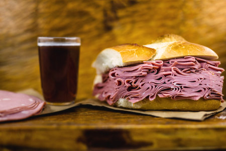 Bread snack with mortadella on a rustic empress table, with typical Brazilian beer.