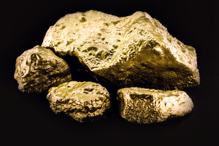 Gold nugget, large gold stone closeup isolated on black background. Concept of finance, luxury or...
