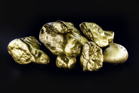 Gold nugget, large gold stone closeup isolated on black background. Concept of finance, luxury or...
