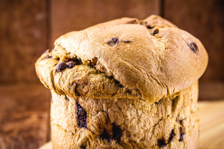 chocolate panettone isolated on rustic wooden background, space for text. Typical Christmas dessert...