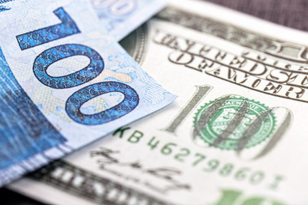 detail of a banknote of one hundred reais from brazil, trapped between banknotes of 100 american...