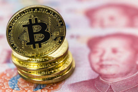 bitcoin coins next to one hundred yuan banknotes, china money, decentralized economy conceptの写真素材