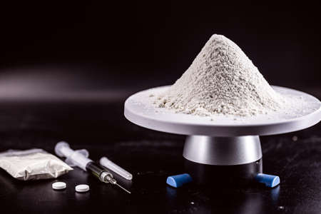 lot and portion of cocaine being weighed on electronic scale, drug trafficking and narcotics productionの写真素材