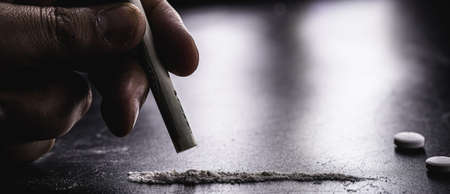 various narcotics on a dark table, consumption or purchase of illegal drugs, pills, cocaine and heroinの写真素材