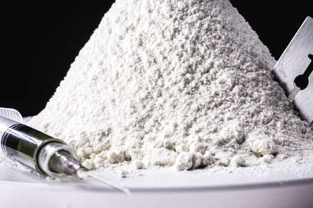 various narcotics on a dark table, consumption or purchase of illegal drugs, pills, cocaine and heroinの写真素材