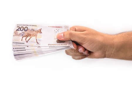 hand holding 200 reais bills, Brazilian money, fgts concept, emergency aid portion, or economy of brazilの写真素材
