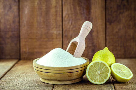 bowl with baking soda and citrus fruits like lemon or orange around. Home remedy against stomach acid, anti acidの写真素材