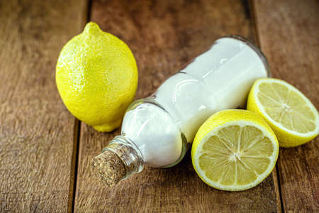 glass with baking soda and citrus fruits like lemon or orange around. Home remedy against stomach acid, anti acidの写真素材
