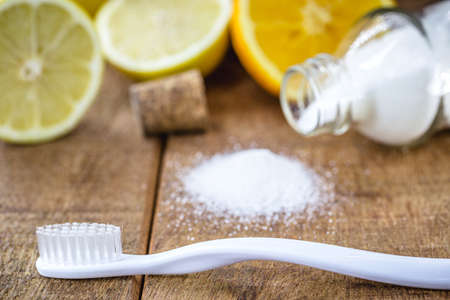 toothbrush with glass with baking soda and citrus fruits like lemon or orange in the background. Spot focusの写真素材