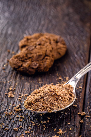 spoon with grated and dark chocolate, chocolate powder used as a filling for sweets. American...