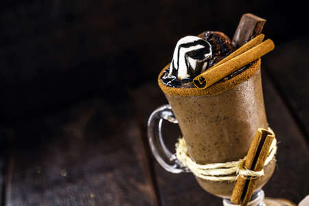 bowl of hot chocolate with hot syrup, marshmallows, cocoa and sugar. Sweet and hot winter drink with black backgroundの写真素材