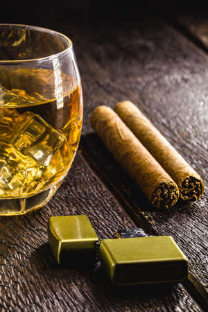 glass of whiskey with ice and cigar, strong drink, concept of relaxing moment, tuxedoの写真素材