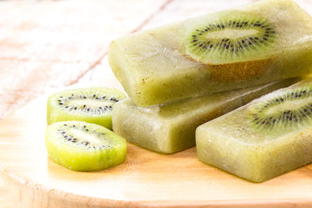 kiwi popsicle on wooden table, homemade and cold dessert, made with fresh fruits without sugarの写真素材