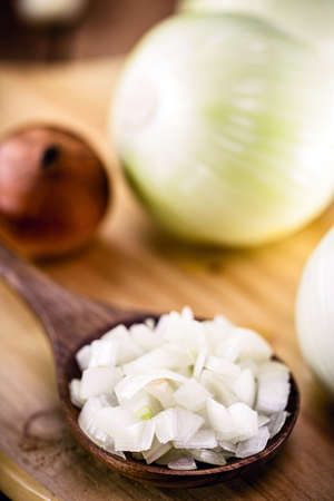 wooden spoon with roasted onion and crushed into pieces to be used as a seasoningの写真素材