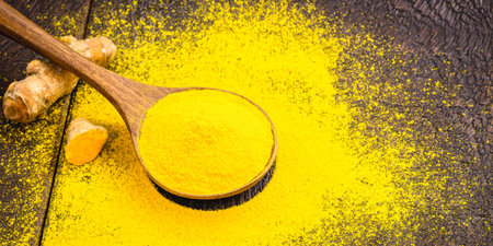 turmeric powder in rustic wooden spoonの写真素材