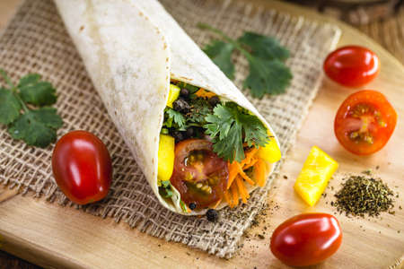 Burritos or vegan wrap, wrapped with mushrooms, pepper, cabbage and other grilled vegetablesの写真素材