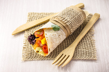 Vegan tortilla wrap, vegetarian roll with grilled vegetables, pepper, lentils, tomatoes and cabbage,...