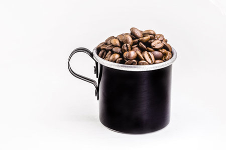 old metallic mug with Brazilian Arabica coffee seeds on white background.の写真素材