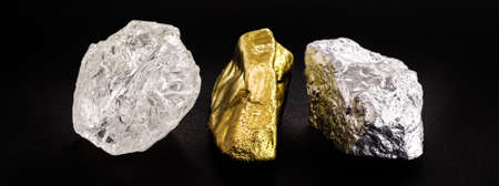 Rough diamond stone with rough gold and silver nuggets on isolated black background.の写真素材