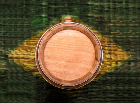 oak barrel with Brazilian flag texture in yellow and green in the background, pinga or cachaÃ§a...