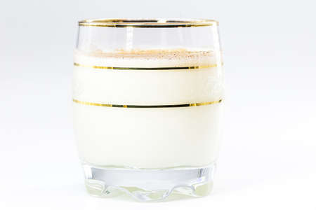 glass of hot eggnog, Christmas drink, made with eggs, cinnamon, almonds and rum liqueur. Isolated white background and copy space.の写真素材