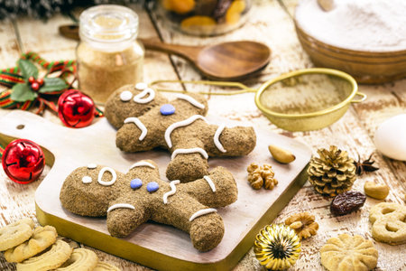 Christmas gingerbread cookies, homemade gingerbread man, being baked, with fruits and nuts around