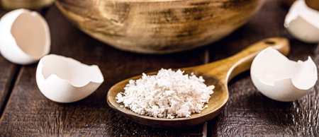 wooden spoon with ground eggshells, used white eggshell prepared for use as fertilizer, leftover...