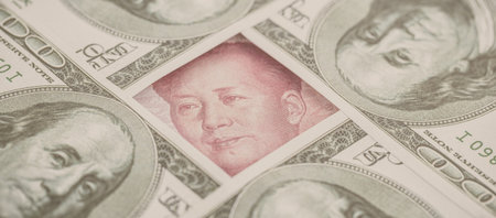 yuan banknote, surrounded by 100 dollar bills. American market protectionism concept