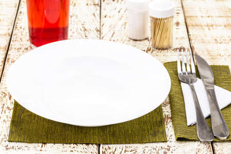top view rustic white table mockup, empty round and white plate for food, cutlery on the side, vintage backdrop, homemade food conceptの写真素材