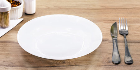 rustic table mockup , top view, empty round and white plate for food, cutlery on the side, vintage...