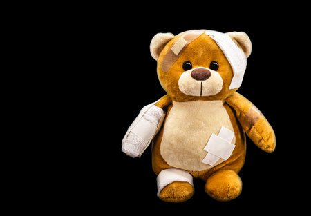 sad injured teddy bear in need of medical care. Conceptual image about violence or child abuse