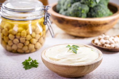 Vegan mayonnaise made from chickpeas and legemus, with a jar of aquafaba in the background, egg or milk-free ingredientの写真素材