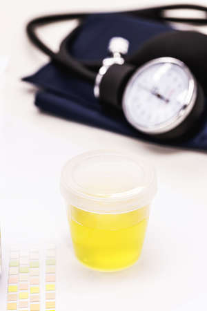 bottle or urine collector with sphygmomanometer on the side, hypertension urine test concept, medical examinationの写真素材