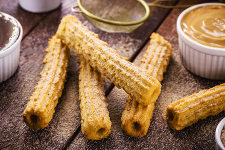 churros, a traditional fried sweet from Latin America, Brazil, Colombia, the United States and Portugal, served with or without filling, sprinkled with sugarの写真素材