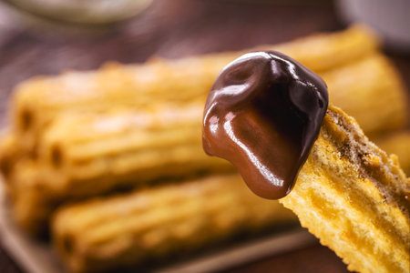 Churros, a typical sweet from Brazil and America, fried and stuffed with creamy chocolate, covered in sugar, tradition in popular festivalsの写真素材