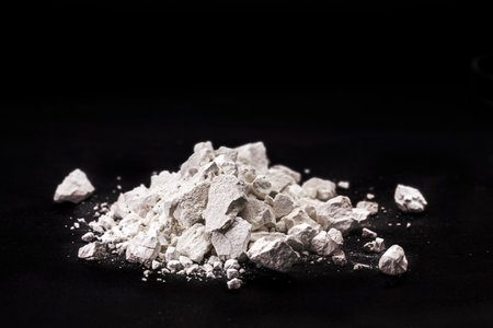 Calcium Chloride flakes, salt in solid state, used in brine for refrigeration machines, road dust and ice control, in cheese and in cement. Industrial use, isolated black background, copyspaceの写真素材