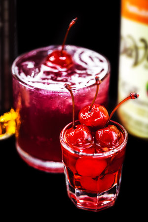 cherry-based refreshing alcoholic drink, red color, sweet taste, isolated black background, called cherry caipirinha or silk stockingの写真素材