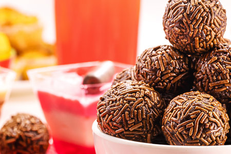Brazilian chocolate bonbon, called Brigadeiro, made with condensed milk, chocolate powder and sprinkles, served with cake at birthday parties , macro photographyの写真素材