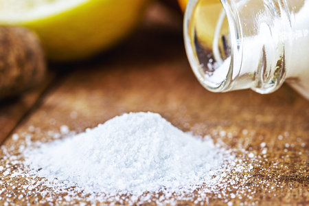 glass of baking soda with citrus fruits around, like lemon or orange, home remedy, macro photography