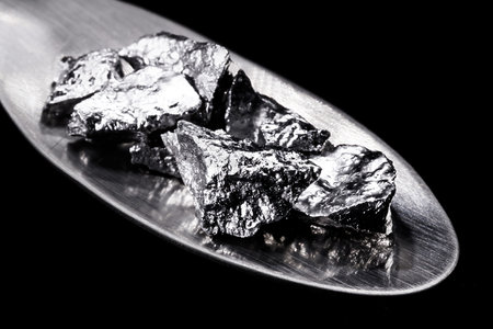 Chromium fragments on trowel, industrial use ore, metallic chemical element, isolated on black...