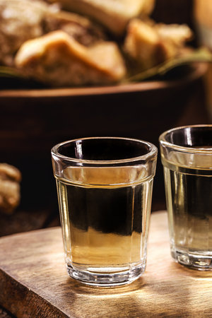 CachaÃ§a, pinga, cana or caninha is the sugar cane brandy, a typical drink from Brazil, with a crackling appetizer in the backgroundの写真素材